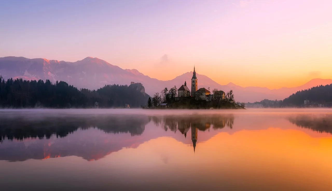 Lac de Bled à l'aube : église de l'Assomption sur l'île et Alpes Juliennes en fond
